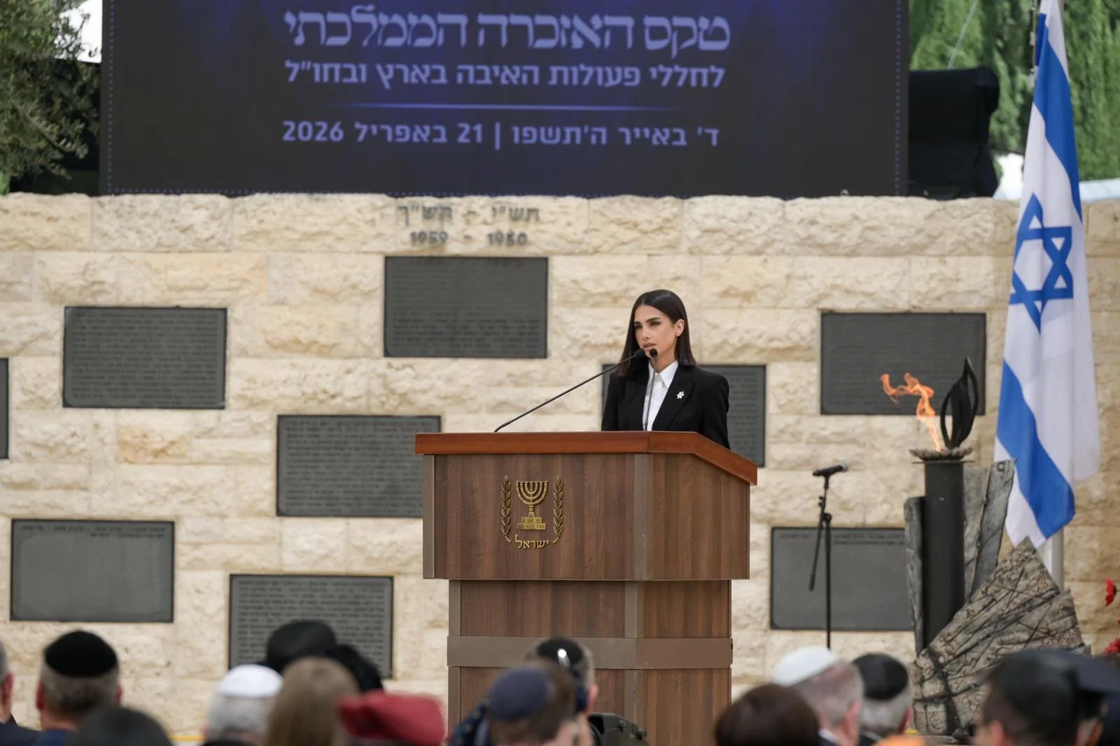 Maggie Tabibi at the lectern during a national memorial ceremony